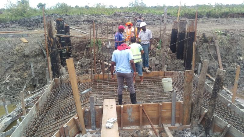 Site personnel discussing construction of Control Structure along an irrigation channel.